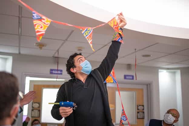 A male volunteer hanging ramadan decorations