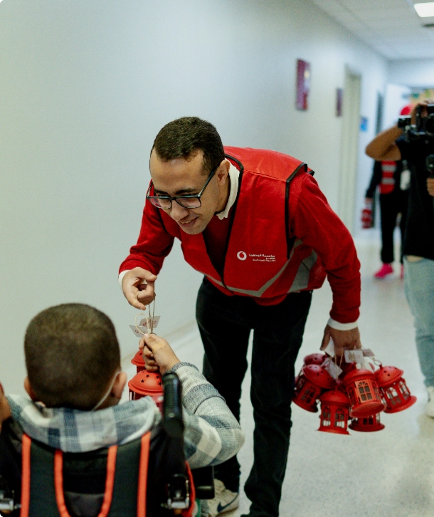 A male volunteer givin a child a gift